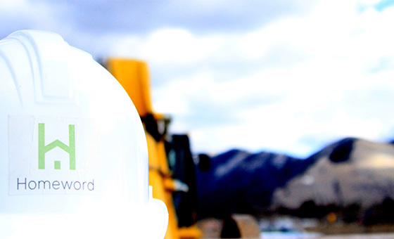 Hard hat with backhoe and mountain in background