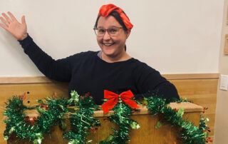 Homebuyer educator Julie Pavlish at podium covered in holiday garland in Solstice Conference Center